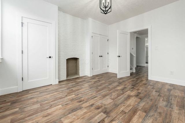 interior space with a large fireplace, a chandelier, and dark hardwood / wood-style floors