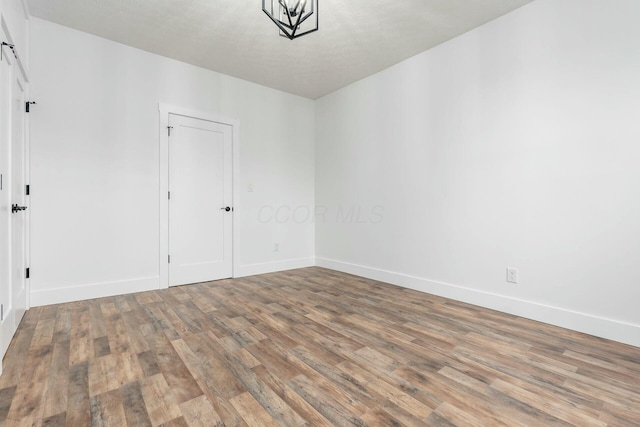 empty room with a barn door and wood-type flooring