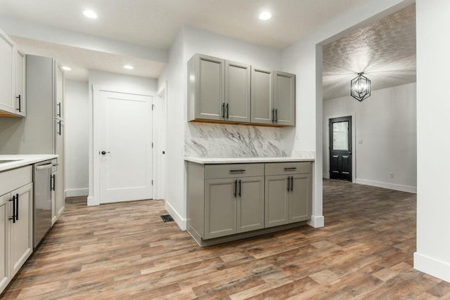 kitchen with dishwasher, gray cabinetry, and hardwood / wood-style floors