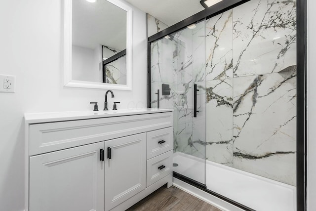 bathroom with hardwood / wood-style flooring, vanity, and a shower with shower door