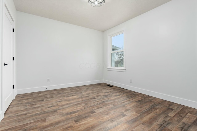 unfurnished room with dark wood-type flooring