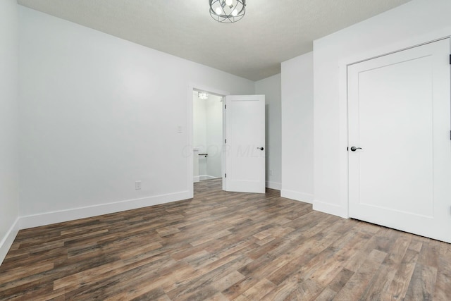 unfurnished bedroom with dark hardwood / wood-style flooring