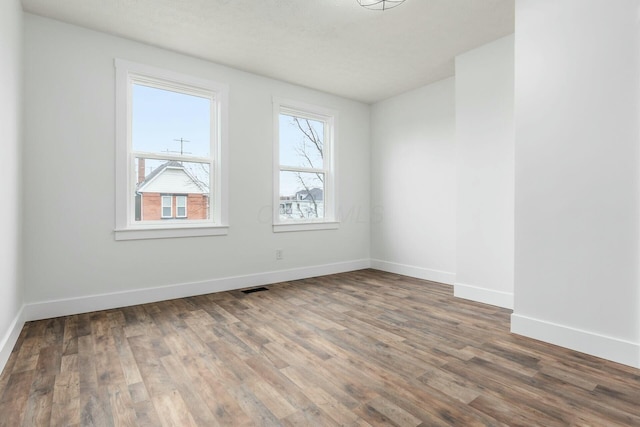 unfurnished room with wood-type flooring