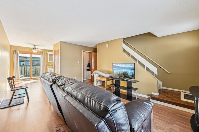 living room featuring light hardwood / wood-style floors and ceiling fan