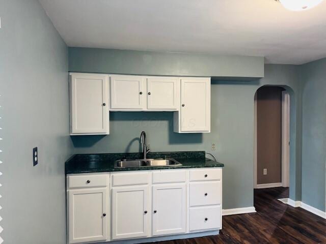 kitchen featuring dark wood-type flooring, sink, and white cabinets