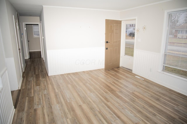 unfurnished room featuring light hardwood / wood-style flooring and ornamental molding