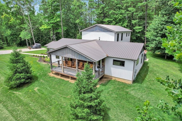 back of property featuring a lawn and covered porch