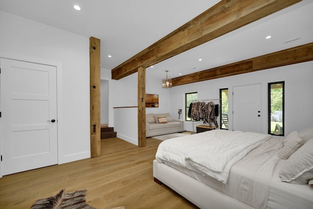 bedroom featuring access to exterior, a notable chandelier, light hardwood / wood-style flooring, and beamed ceiling