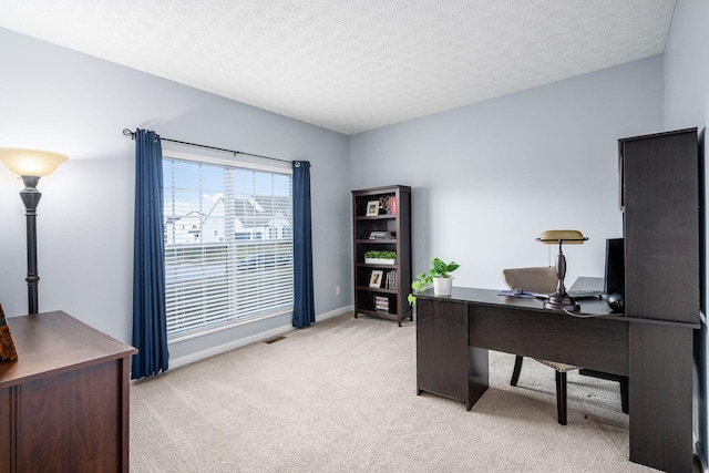 carpeted home office with a textured ceiling