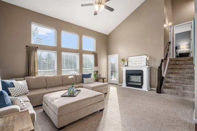 carpeted living room featuring ceiling fan and high vaulted ceiling