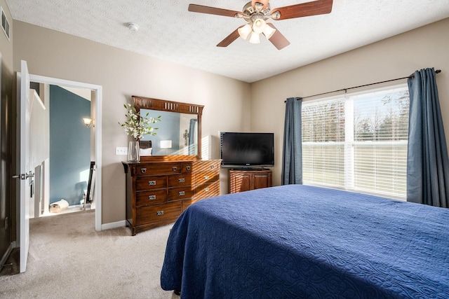 carpeted bedroom with ceiling fan and a textured ceiling