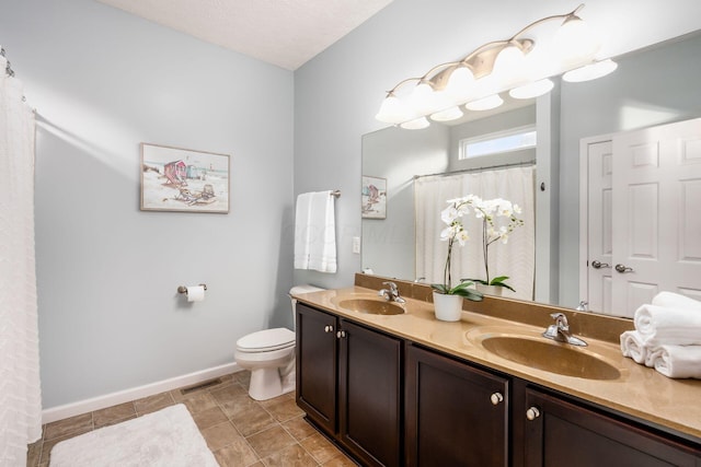 bathroom featuring tile patterned floors, vanity, toilet, and a textured ceiling