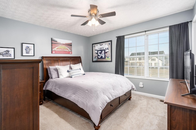 carpeted bedroom with ceiling fan and a textured ceiling