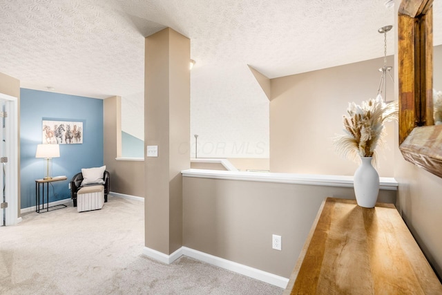 corridor with carpet and a textured ceiling