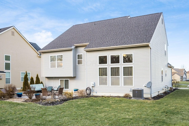 back of property featuring central AC unit, a patio area, and a lawn