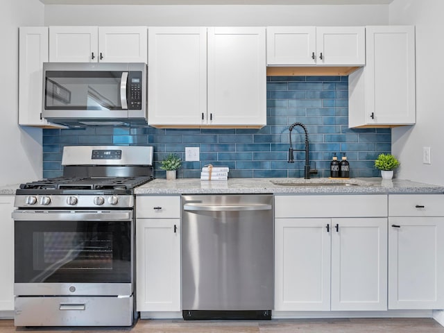 kitchen with white cabinets and appliances with stainless steel finishes