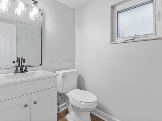 bathroom featuring vanity, toilet, hardwood / wood-style floors, and a textured ceiling