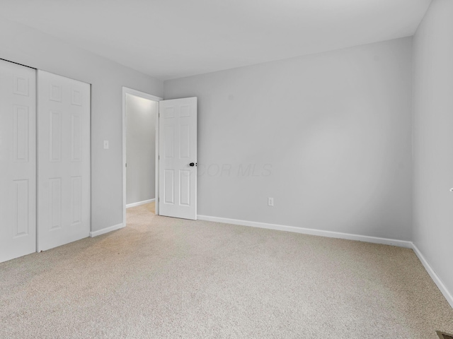 unfurnished bedroom featuring carpet flooring and a closet