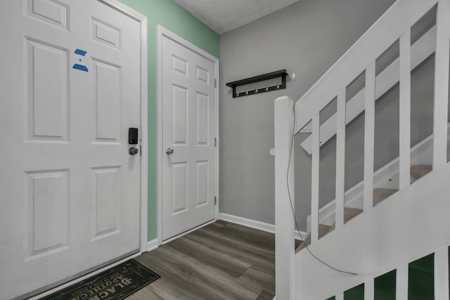 foyer entrance with dark wood-type flooring and a textured ceiling