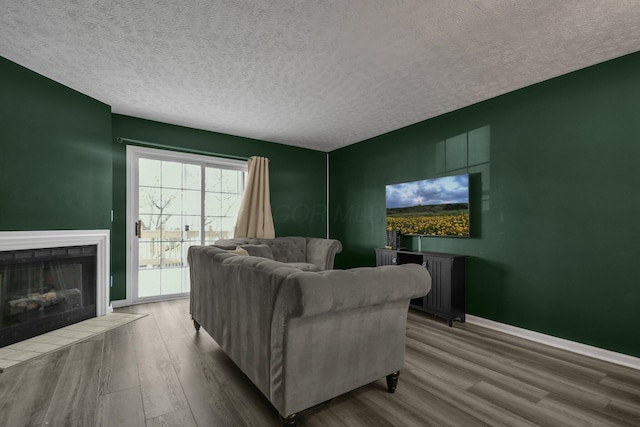 living room with hardwood / wood-style flooring, radiator heating unit, a textured ceiling, and a fireplace