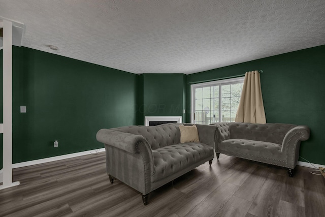 living room with dark wood-type flooring and a textured ceiling