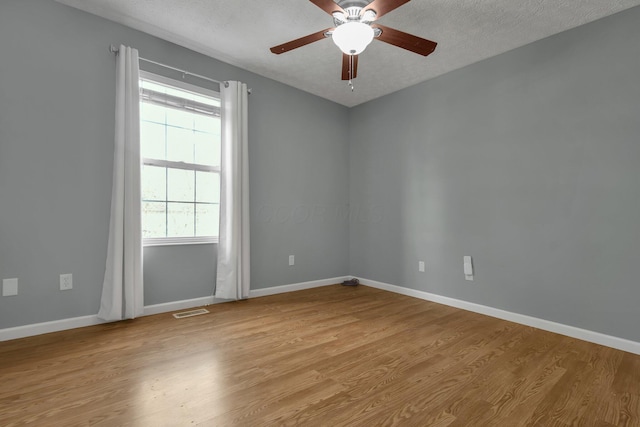 spare room with ceiling fan, light hardwood / wood-style flooring, and a textured ceiling