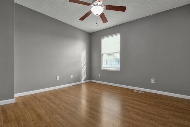 unfurnished room featuring wood-type flooring, ceiling fan, and a textured ceiling