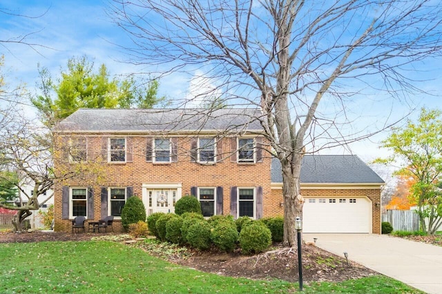 colonial house with a garage and a front lawn