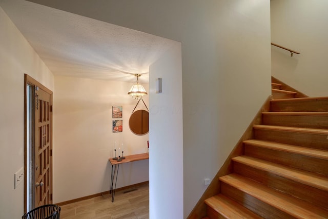 stairway featuring hardwood / wood-style floors and a textured ceiling