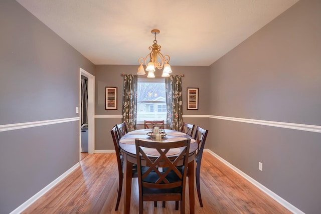 dining space with an inviting chandelier and light hardwood / wood-style floors