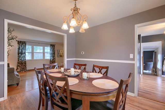 dining space with an inviting chandelier and light wood-type flooring