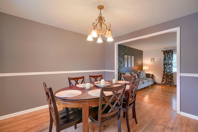 dining room with a notable chandelier and light wood-type flooring