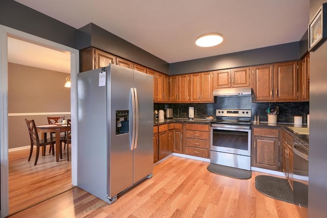 kitchen with stainless steel appliances, light wood-type flooring, and decorative backsplash