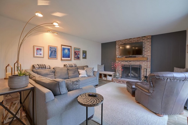 living room with a brick fireplace and light hardwood / wood-style flooring