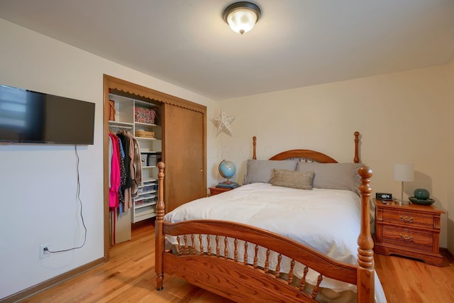 bedroom with light hardwood / wood-style floors and a closet