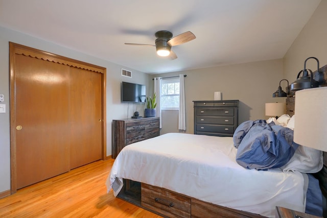 bedroom with light hardwood / wood-style floors, a closet, and ceiling fan