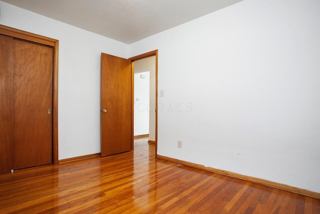 unfurnished bedroom with a closet and light wood-type flooring