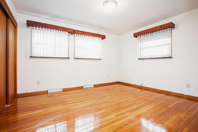 empty room featuring wood-type flooring and a wealth of natural light