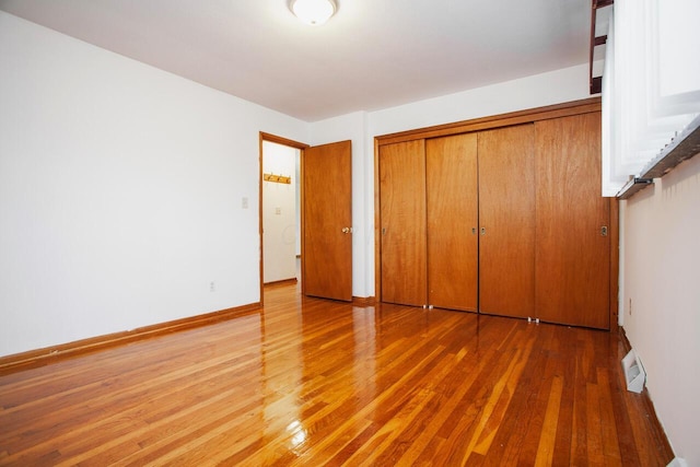 unfurnished bedroom featuring hardwood / wood-style floors and a closet