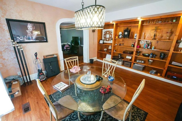 dining space featuring hardwood / wood-style flooring and a chandelier