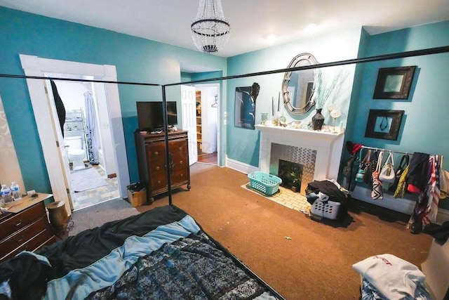 bedroom featuring a tiled fireplace, carpet, and a notable chandelier