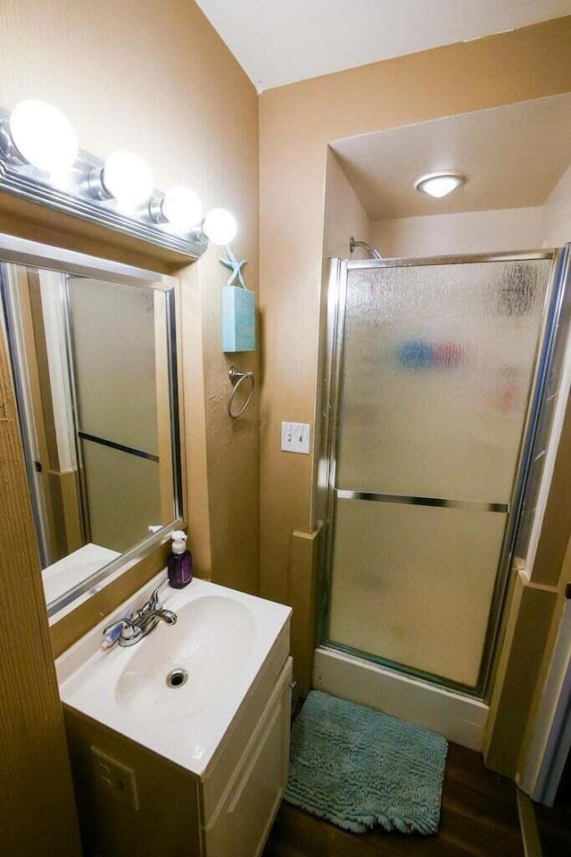 bathroom featuring a shower with door, vanity, and hardwood / wood-style flooring