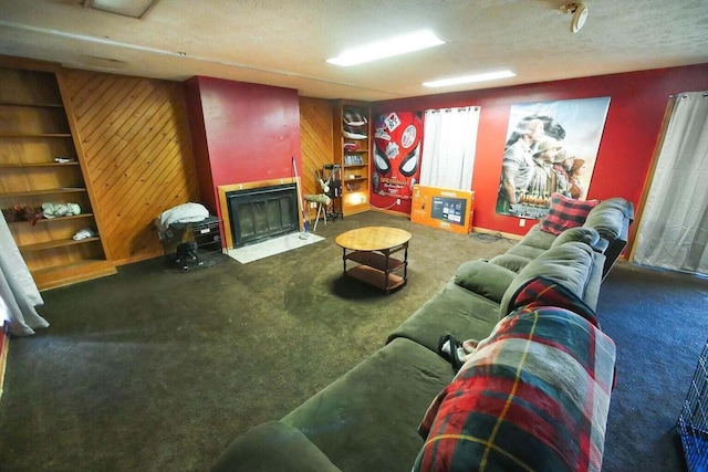 living room featuring dark carpet, wooden walls, and a textured ceiling