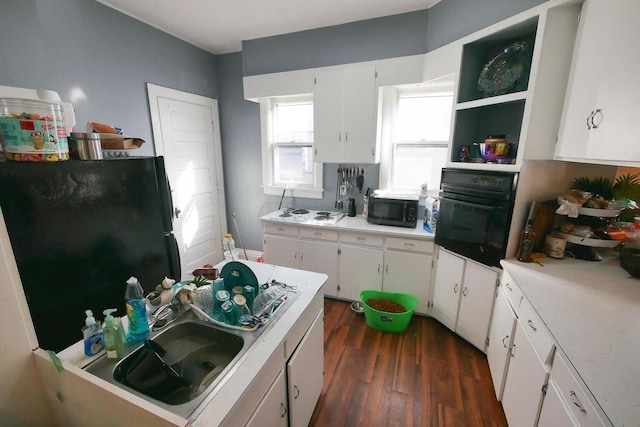 kitchen featuring white cabinetry, sink, black appliances, and dark hardwood / wood-style floors