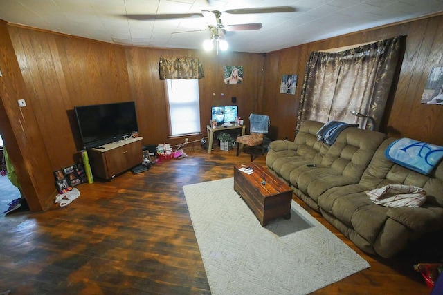 living room featuring ceiling fan, dark hardwood / wood-style flooring, and wood walls