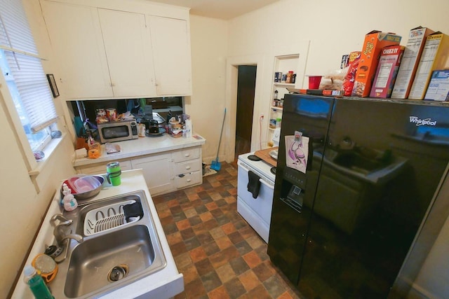 kitchen featuring sink, white range with electric stovetop, black refrigerator with ice dispenser, and white cabinets