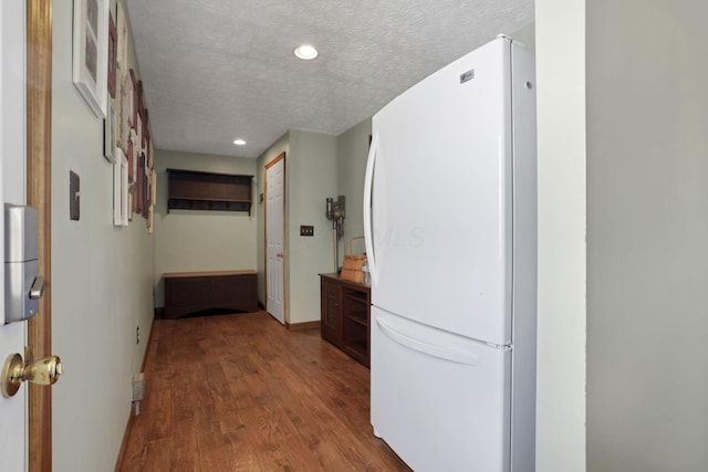 hall featuring recessed lighting, baseboards, a textured ceiling, and wood finished floors