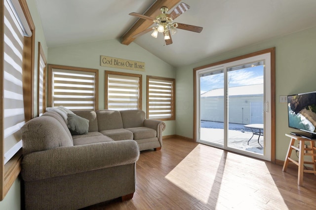 living room featuring baseboards, ceiling fan, lofted ceiling with beams, and light wood finished floors