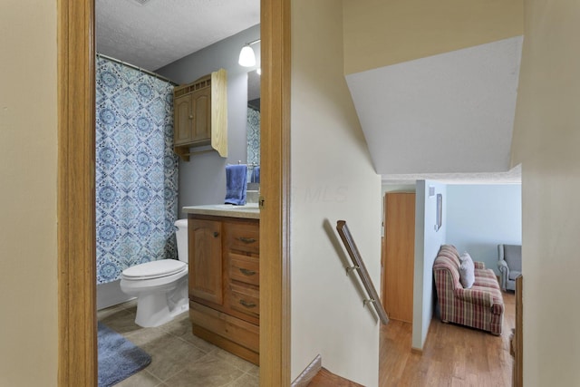 full bath featuring toilet, a textured ceiling, and vanity