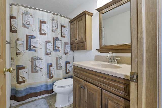 full bath featuring curtained shower, vanity, toilet, and a textured ceiling